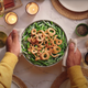 Green bean casserole being placed on Thanksgiving table